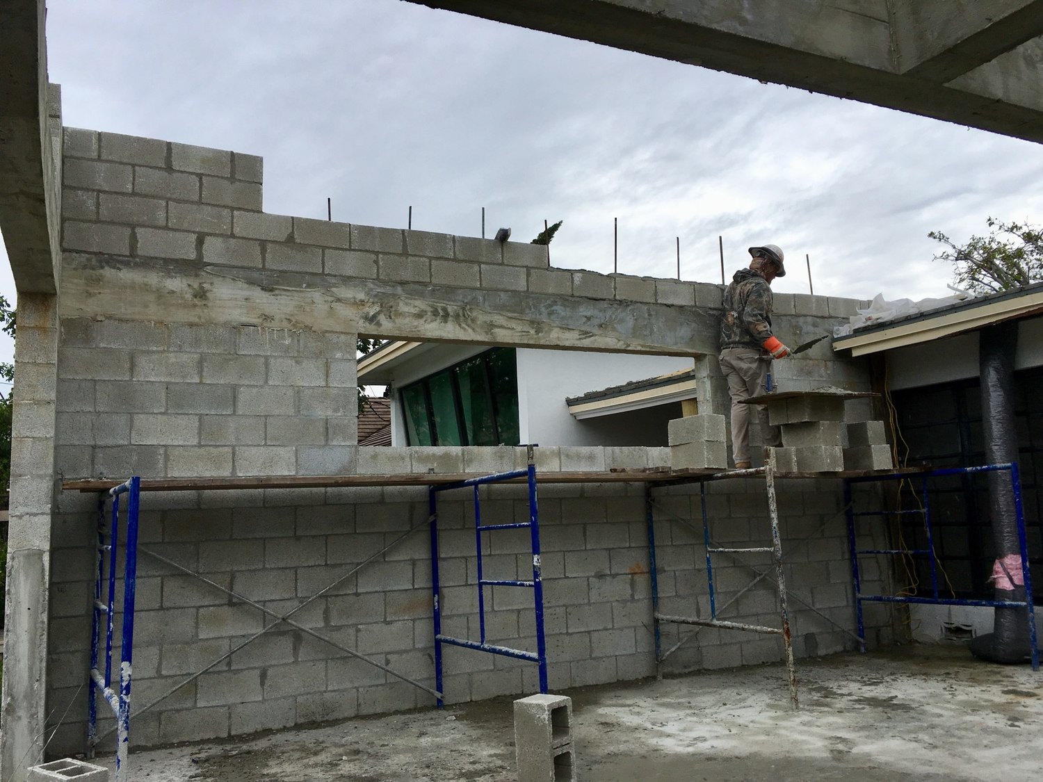 Laying the top courses of block from scaffold along the new addition wall