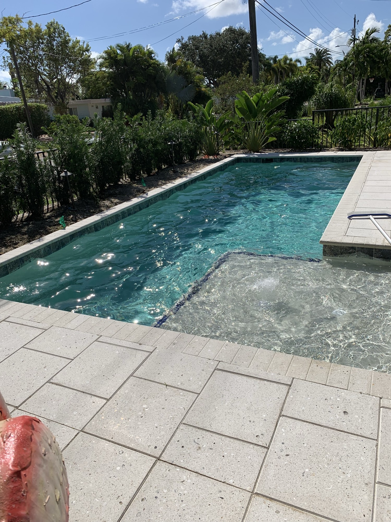 Completed pool with a sun shelf and tanning ledge, surrounded by a large-format stone deck