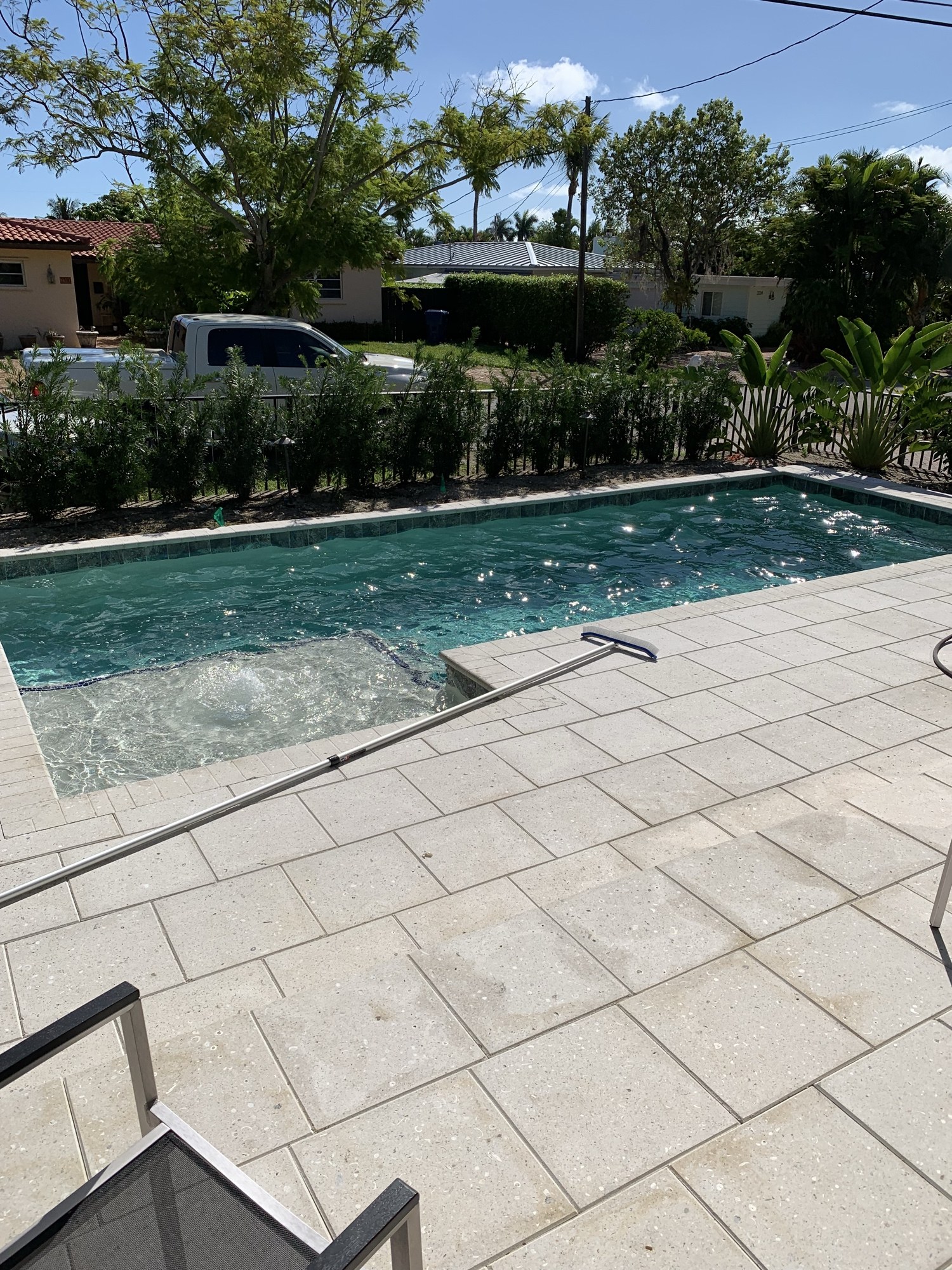 The completed pool and stone deck looking toward the hedge and the street