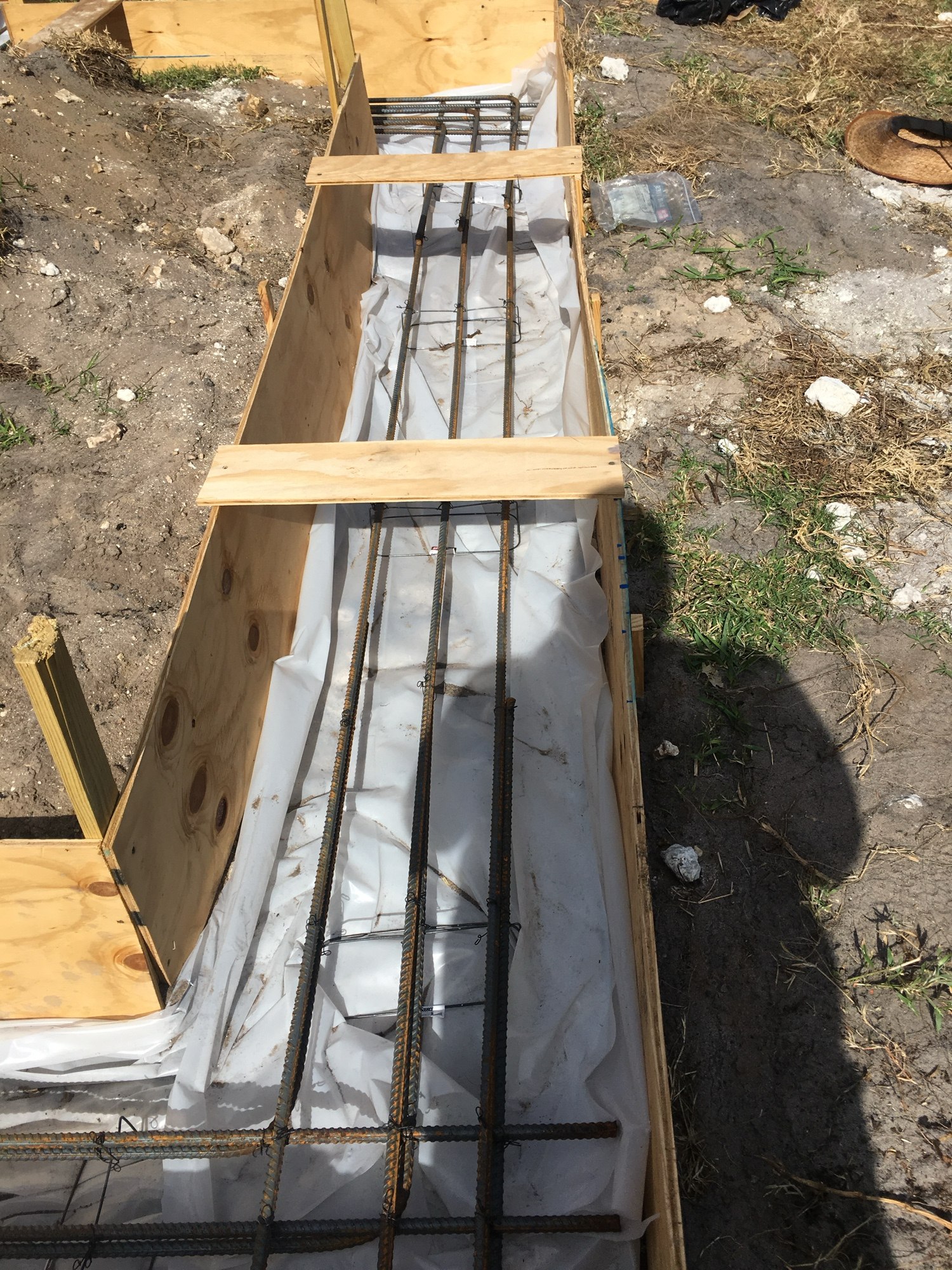 Footing formwork with reinforcing steel tied and vapor barrier in place before the pour