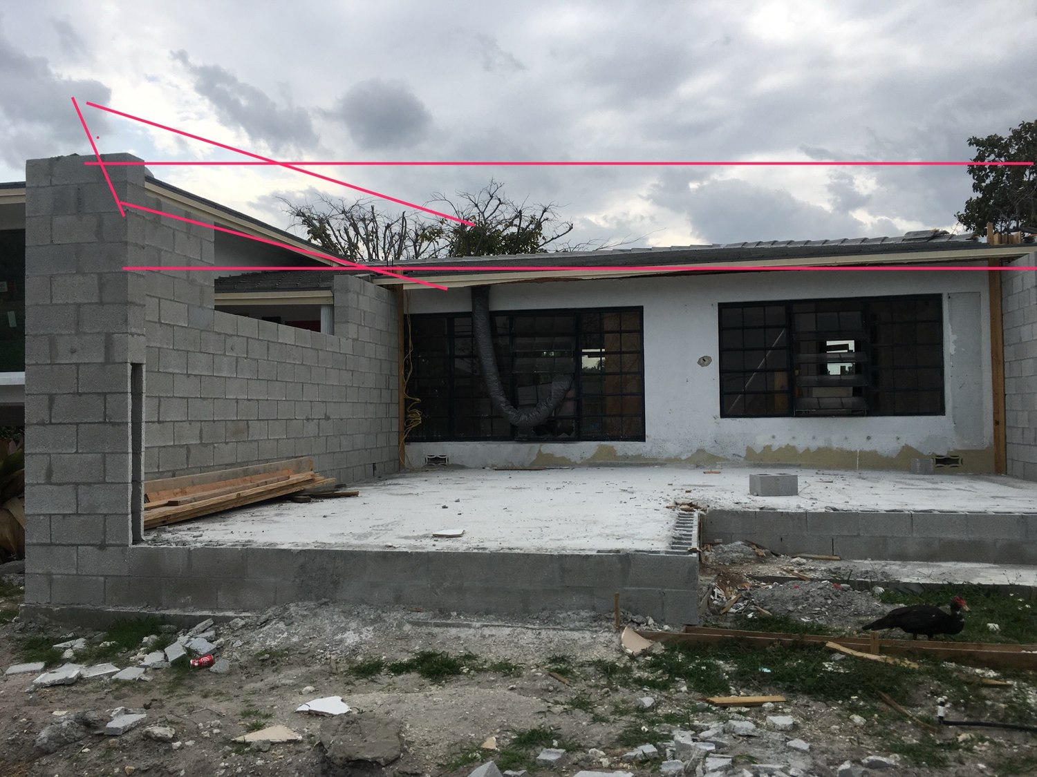Photograph of the block structure marked up by hand in pink to study the new roof line against the existing house
