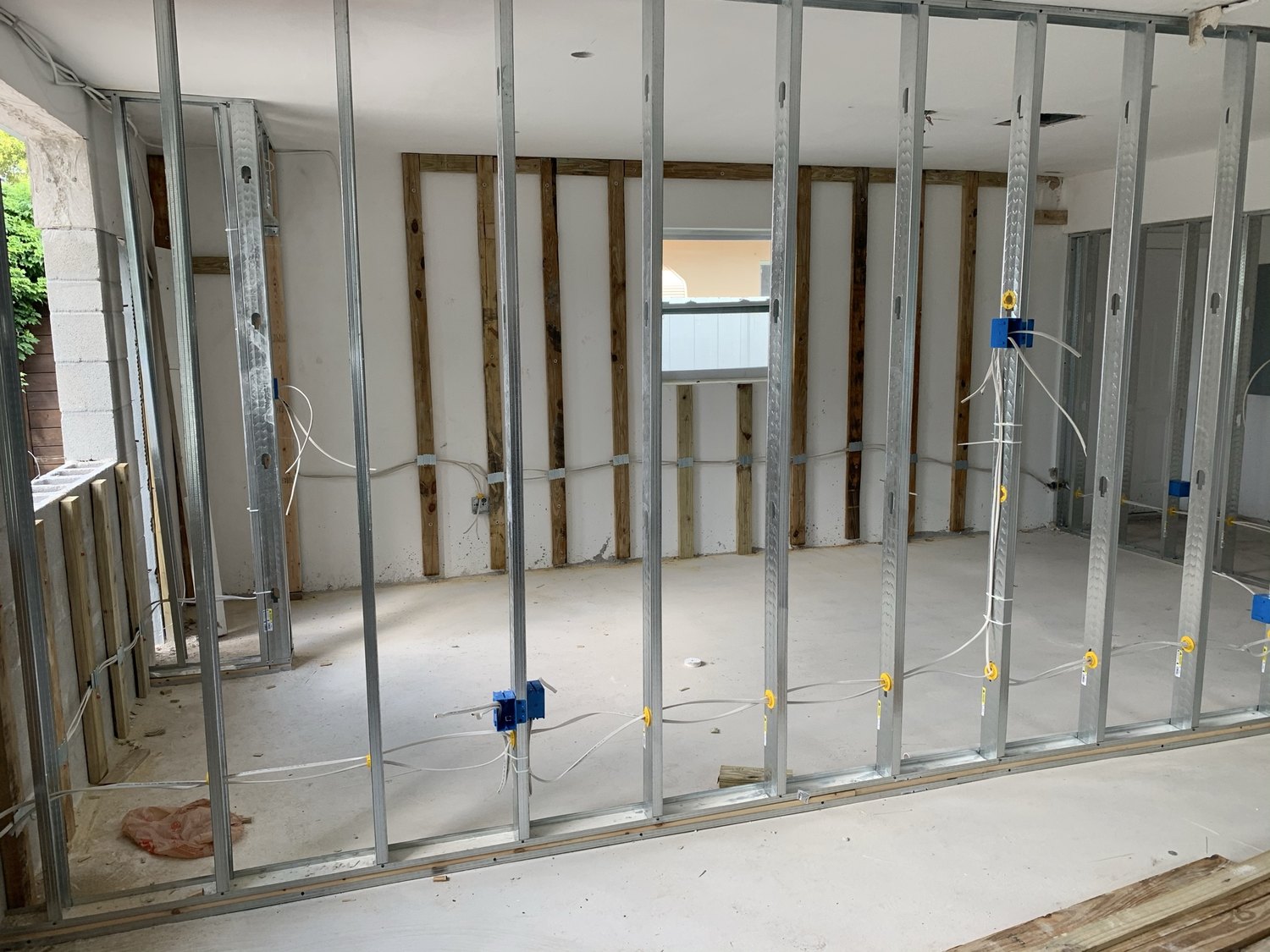 Metal stud framing with electrical boxes and wiring set before drywall