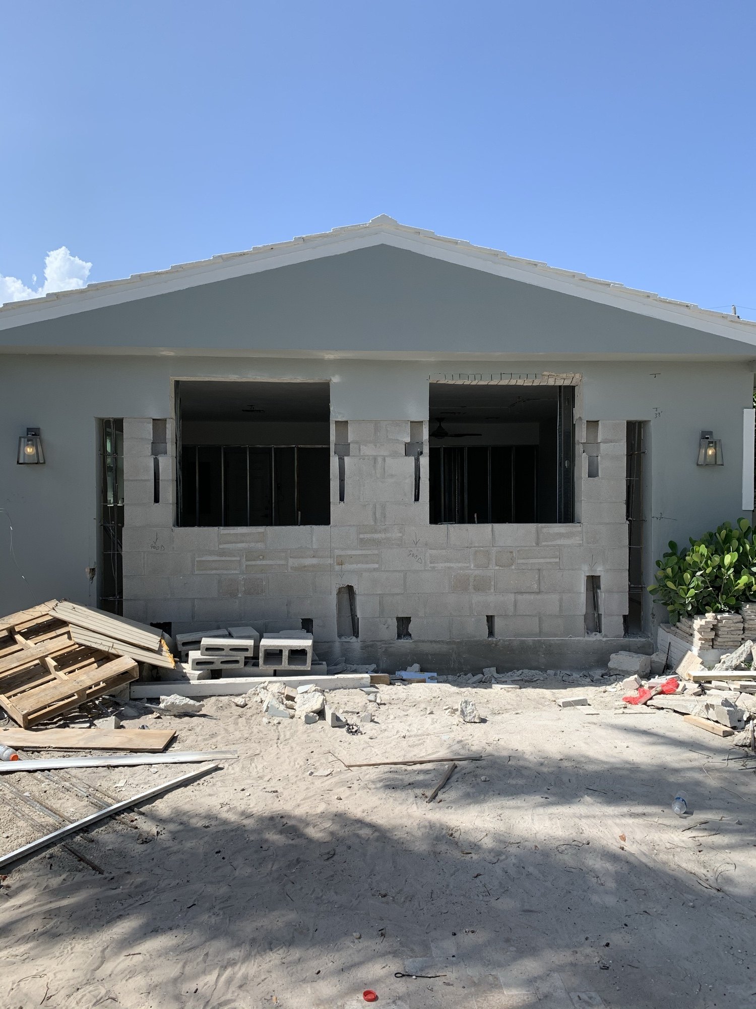 Concrete block wall with new window openings cut through and headers in place