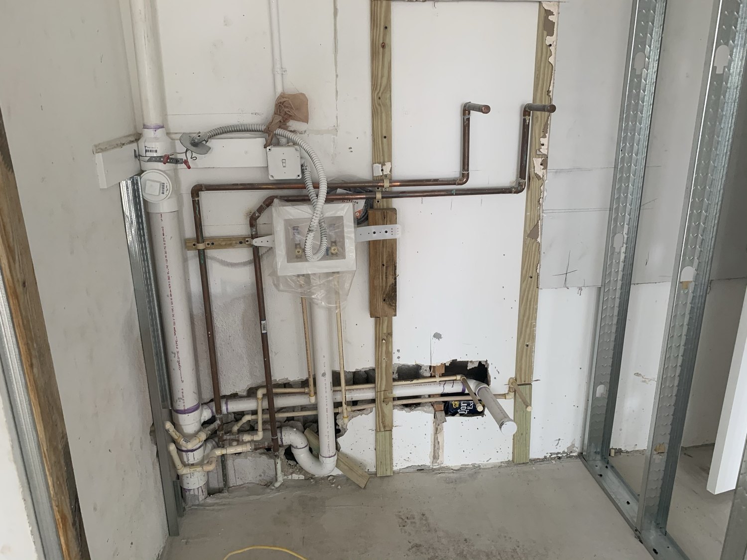 Rough plumbing for a bathroom with copper supply lines and a shower valve set in the wall