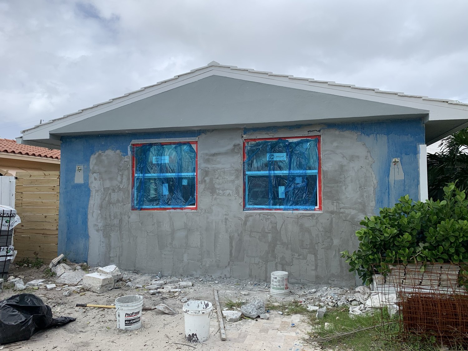 Exterior of the converted garage with new windows masked and stucco patched before paint