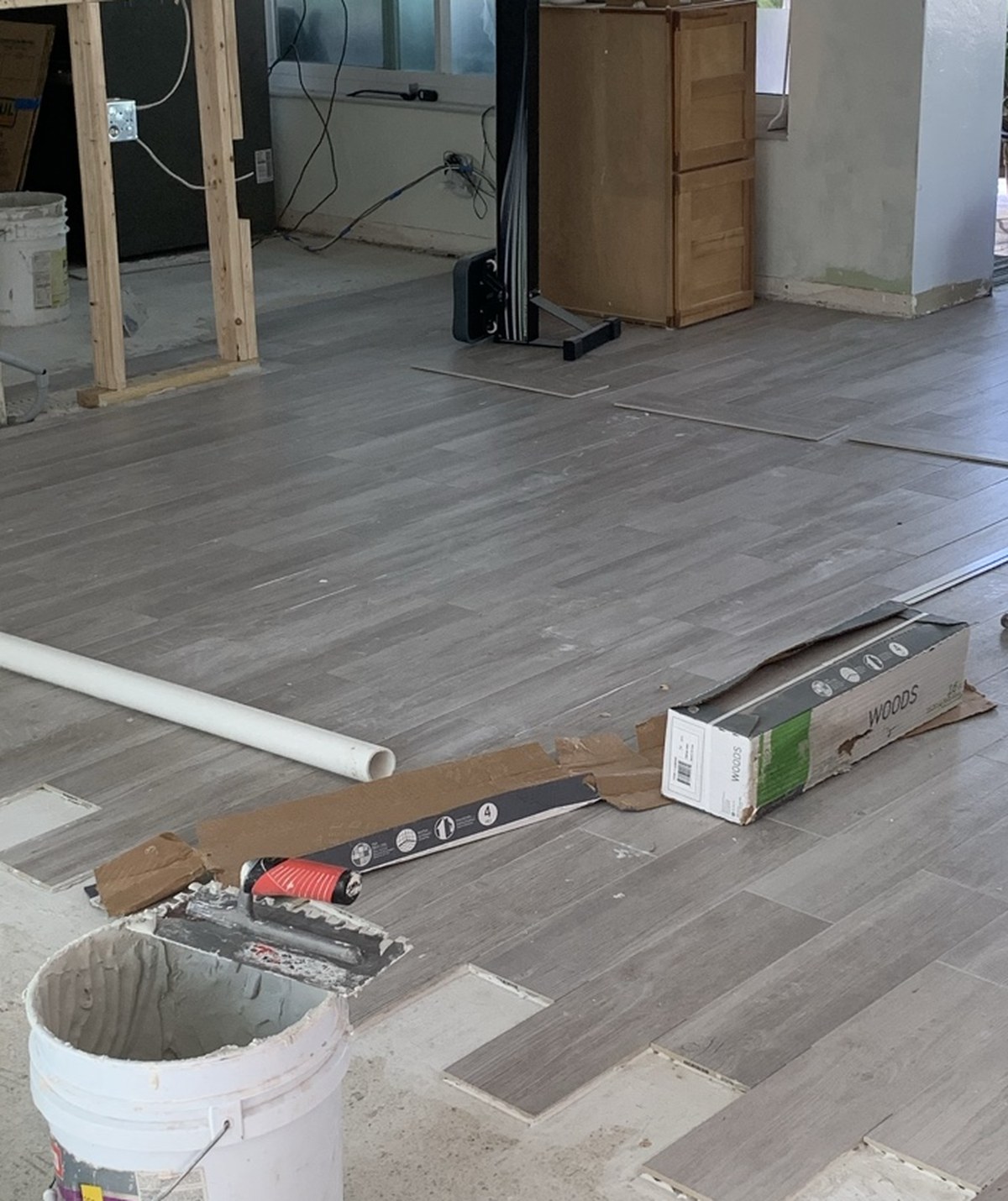 Plank tile being set over the old floor with thinset and a notched trowel