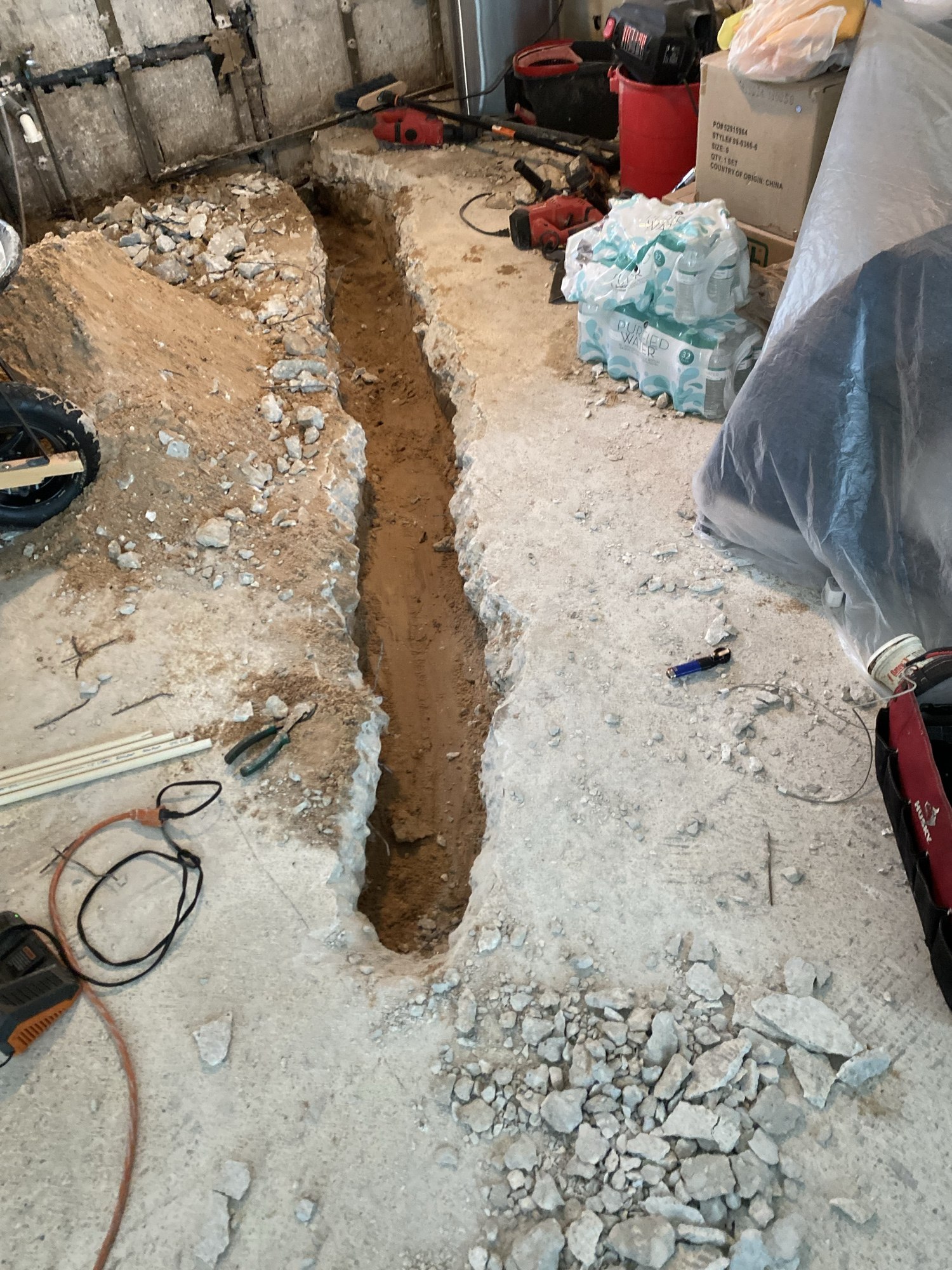 Trench cut through the concrete slab for new drain lines