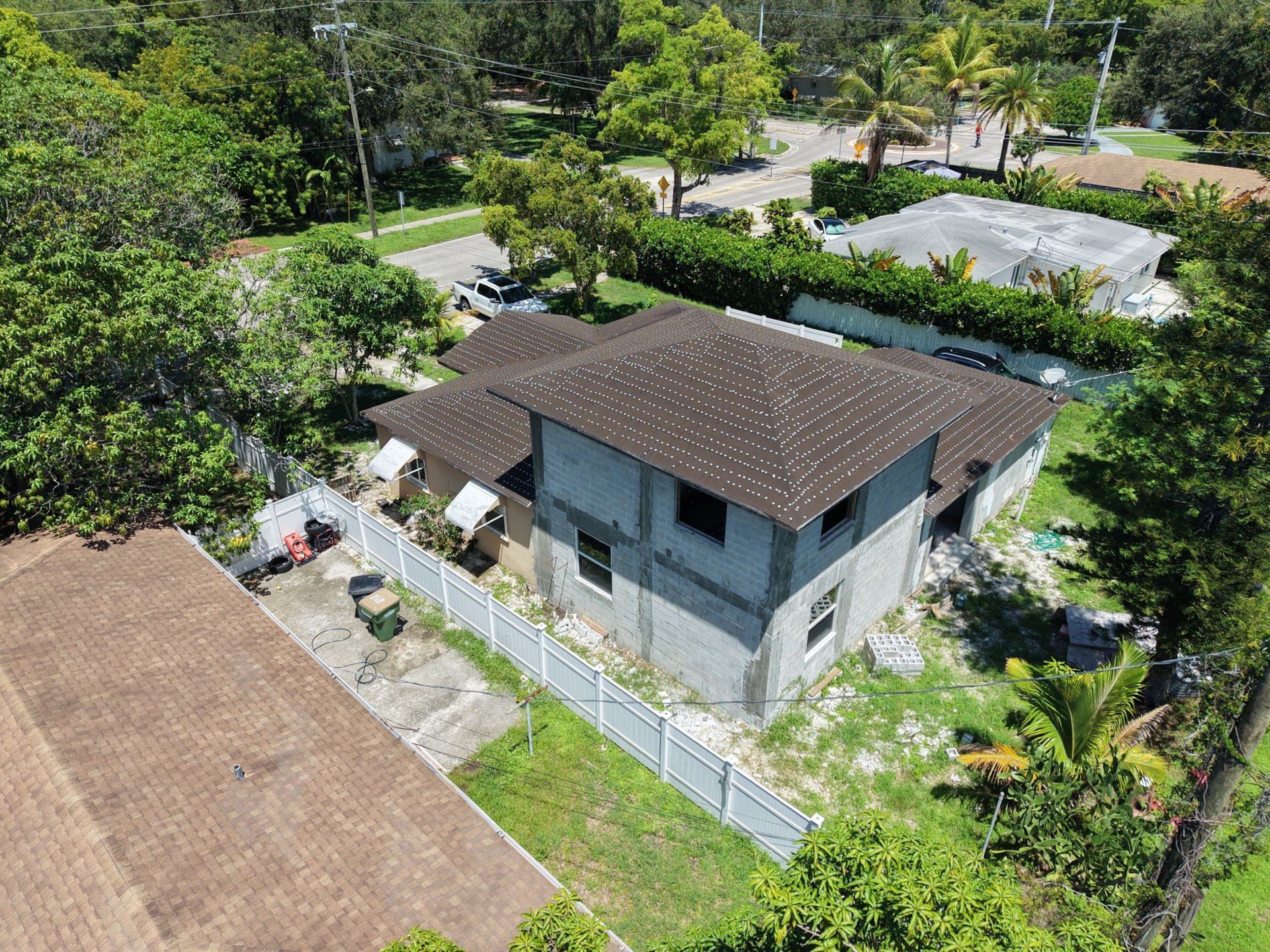 Aerial view of a home renovation showing the new concrete block second-story addition and completed roof underlayment