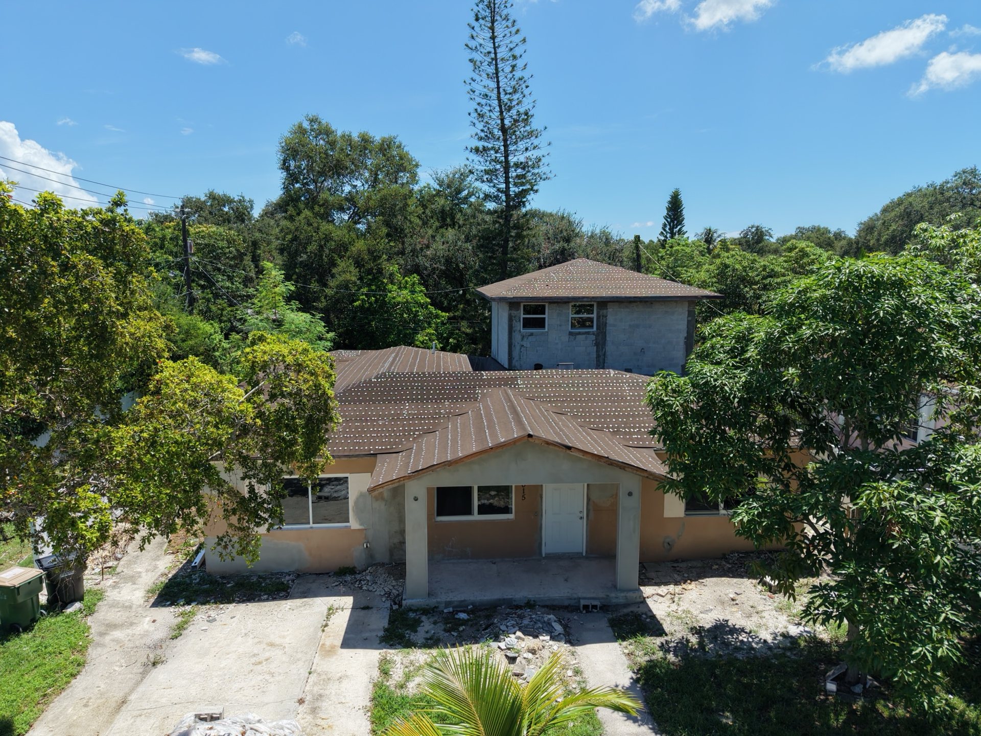 Front elevation of a South Florida home mid-renovation with a new concrete block second story and new roof