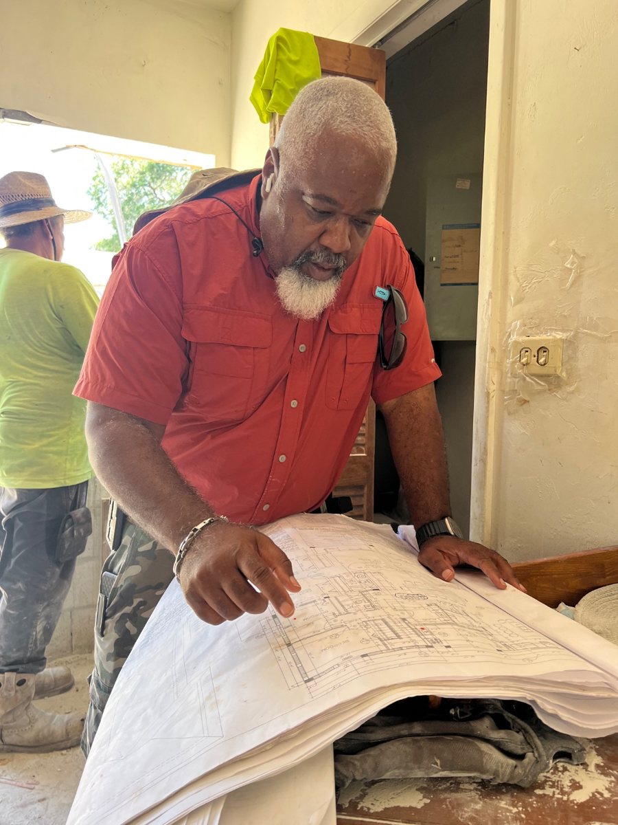 Reviewing construction drawings on site with a crew member during a renovation