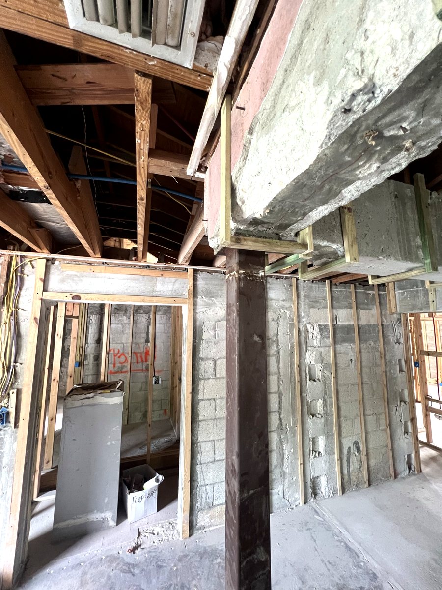 Temporary shoring and framing supporting a concrete beam during structural interior renovation