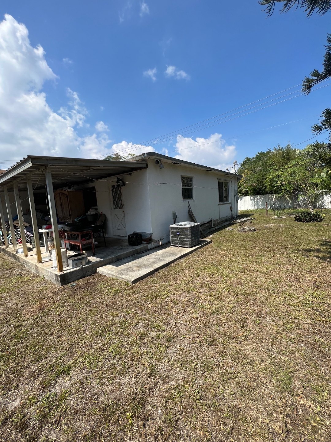 The single-story home as it stood before work began, with the original carport and tile roof