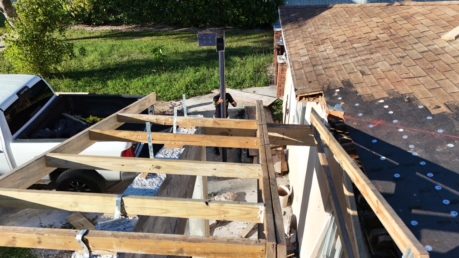 Roof sheathing going on over the new framing, aerial view