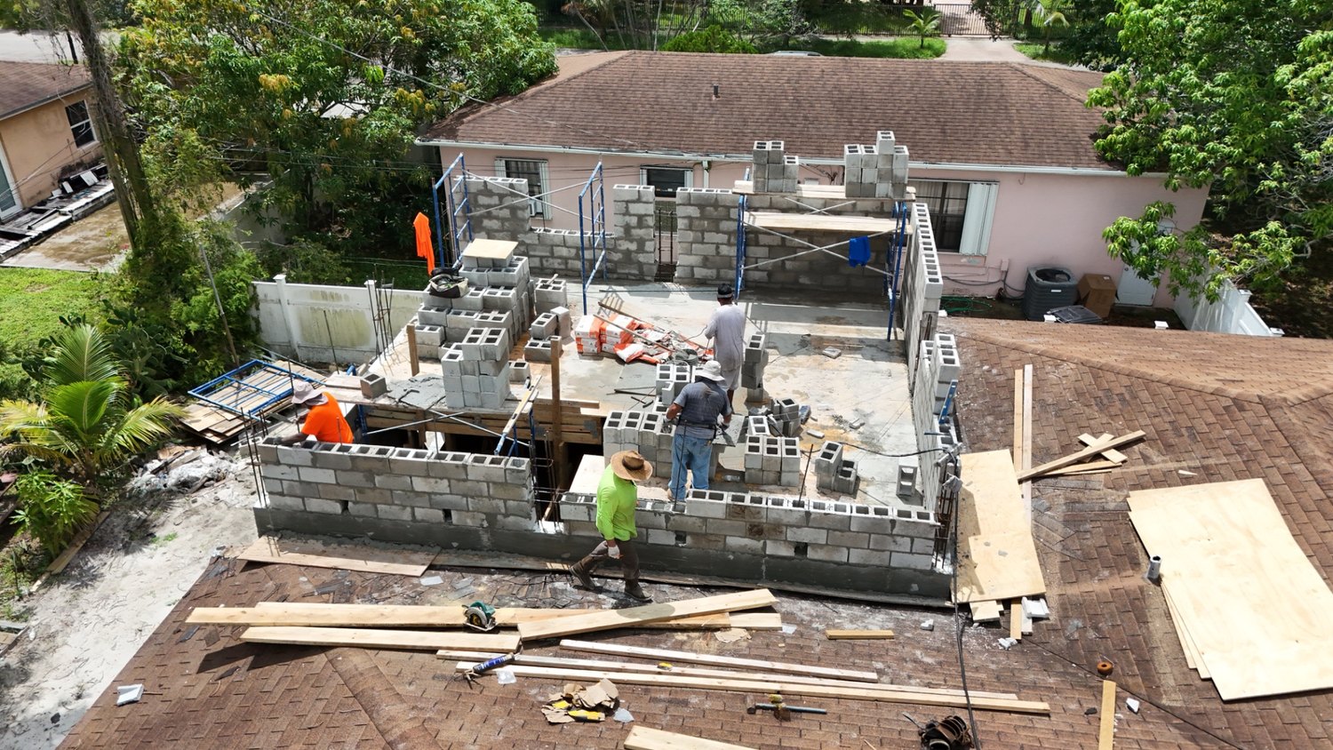 Aerial view of the concrete block walls going up on the new addition behind the house